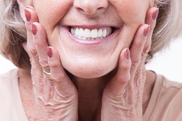 Woman pressing her hands to her jaw and smiling